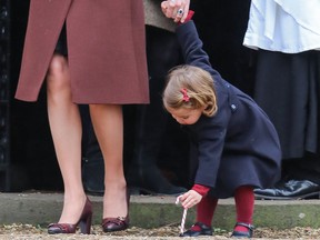 Princess Charlotte plays with a candy cane as the Duchess of Cambridge departs St. Mark's Church, Englefield, on Dec. 25, 2016.