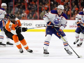Edmonton Oilers' Connor McDavid tries to make a play while Philadelphia's Wayne Simmonds uses his stick on McDavid's hands in the third period of their game on Thursday, Dec. 8, 2016.