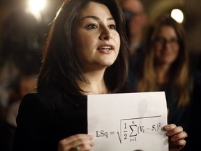 Minister for Democratic Institutions Maryam Monsef holds up the Gallagher equation as she talks with reporters after Question Period in Ottawa, Thursday, Dec. 1, 2016.