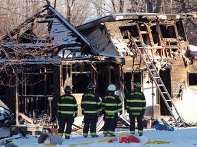 Firefighters and Ontario Fire Marshall officials at the scene of a fatal house fire on Oneida Nation of the Thames, southwest of London, Ont., Dec. 15, 2016.