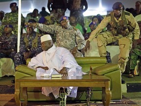 Gambian officers signal to the media not to block the public's view during President Yahya Jammeh's final rally in Banjul, Gambia, Tuesday Nov. 29, 2016.