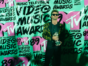 In this Wednesday, Sept. 6, 1989 file photo, musician George Michael holds his trophy after winning the 1989 Video "Vanguard Award" for his "Father Figure" video during the MTV Music Awards at the Universal Amphitheatre in Universal City, Calif.