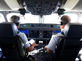 Pilots sit in the cockpit of a plane in this file photo.