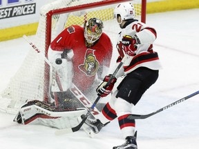 Senators goaltender Mike Condon makes a save as New Jersey Devils' Kyle Palmieri looks on during the second period of their game in Ottawa on Saturday night.