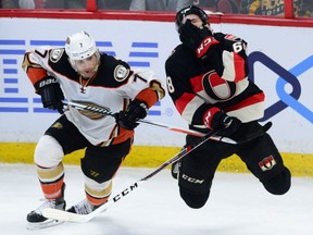 Senators forward Mike Hoffman holds his face after getting high-sticked by the Anaheim Ducks' Andrew Cogliano during overtime in Ottawa on Thursday. Hoffman scored on the ensuing power play to beat the Ducks 2-1.