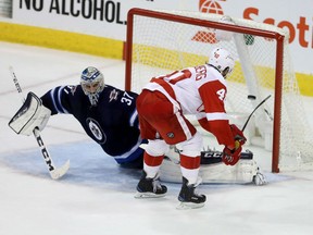 Detroit Red Wings' Henrik Zetterberg scores on Winnipeg Jets goaltender Connor Hellebuyck during the shootout in Winnipeg on Tuesday. Detroit won 4-3.