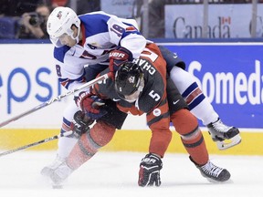 Canada defenceman Thomas Chabot and United States forward Colin White battle for the puck during the first period of Saturday's world junior hockey game in Toronto.