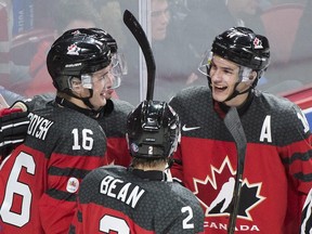 Canada's Taylor Raddysh (left) celebrates with teammates Jake Bean (centre) and Mathew Barzal after scoring against Finland in exhibition play on Dec. 19.