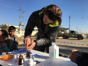 Ian MacKay of Squamish, BC, distributes medicine and medical care only metres away from where several suspected ISIL members were pulled from a line by Iraqi security forces.