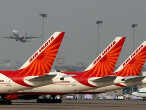 Air India planes are parked in a row, as a Spice Jet plane takes off at the Indira Gandhi International airport in New Delhi, India, Tuesday, May 8, 2012.