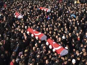 People carry the coffins of bomb victims during a memorial in Istanbul, Sunday, Dec. 11, 2016, for police officers killed outside the Besiktas football club stadium Vodafone Arena late Saturday.