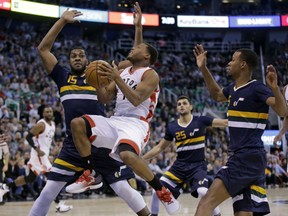 Toronto Raptors' Kyle Lowry drives the hoop against Utah Jazz defender Derrick Favors during NBA action Friday in Utah. Lowry had a game high 36 points including 19 in the fourth quarter as the Raptors posted a 104-98 victory.