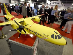 Delegates pass a model of the Airbus C-295 fixed wing search and rescue aircraft at the Canadian Association of Defence and Security Industries' CANSEC trade show in Ottawa on May 27, 2015.