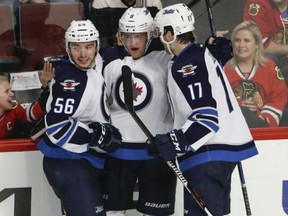 Winnipeg Jets centre Andrew Copp, centre, celebrates with Marko Dano, left, and Adam Lowry, right, after scoring against the Chicago Blackhawks during the third period on Sunday in Chicago. The Jets won 2-1.