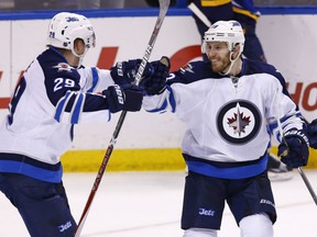 Winnipeg Jets' Bryan Little, right, celebrates with Patrik Laine after scoring the game-winning goal in overtime against the Blues in St. Louis on Saturday night. The Jets won the game 3-2.