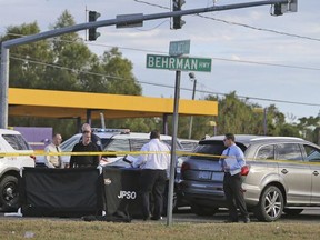 The body of former NFL player Joe McKnight lies between the shooter's vehicle at left and his Audi SUV at right as the Jefferson Parish Sheriff's Office investigates the scene in Terrytown, La., Thursday, Dec. 1, 2016.