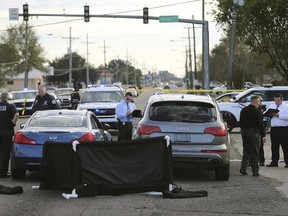 The body of former NFL player Joe McKnight lies between the shooter's vehicle at left and his Audi SUV at right as the Jefferson Parish Sheriff's Office investigates the scene in Terrytown, La., on Dec. 1.