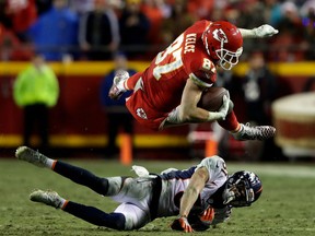 Kansas City Chiefs' tight-end Travis Kelce is knocked off his feet by Denver Broncos' defender Justin Simmons during NFL action Sunday night in Kansas City. Kelce had a big night with 11 catches for 160 yards and a touchdown as the Chiefs humbled the Broncos 33-10 to keep their AFC West title hopes alive. The defending Super Bowl champion Broncos were eliminated from playoff contention.