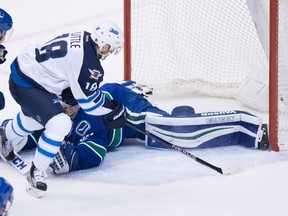 Winnipeg Jets Bryan Little tries to jam the puck past the left pad of Vancouver Canucks' goaltender Ryan Miller during NHL action Thursday night in Vancouver. The Jets made it three wins in their last four games with a 4-1 victory heading into the Christmas break.