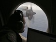 In this March 22, 2014 file photo, flight officer Rayan Gharazeddine scans the water in the southern Indian Ocean off Australia from a Royal Australian Air Force AP-3C Orion during a search for the missing Malaysia Airlines Flight MH370.