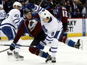 Toronto Maple Leafs defenceman Connor Carrick knocks over the Colorado Avalanche's Joe Colborne in the first period of their game Thursday night in Denver.