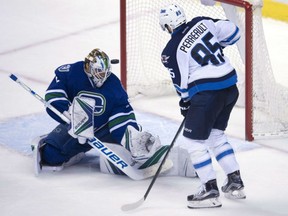 Vancouver Canucks' goaltender Jacob Markstrom stops Mathieu Perreault of the Winnpeg Jets from close in during NHL action Tuesday in Vancouver. The Canucks were 4-1 winners.