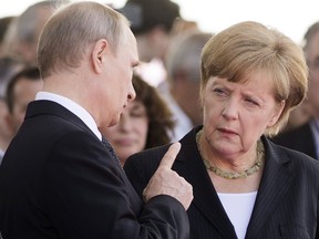 German Chancellor Angela Merkel speaks with Russian President Vladimir, June 6, 2014