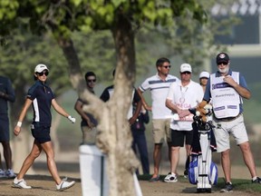 Anne-Lise Caudal of France studies her shot next to her caddie on the 10th hole during the 1st round of Dubai Ladies Masters golf tournament in Dubai, United Arab Emirates, Wednesday, Dec. 7, 2016.