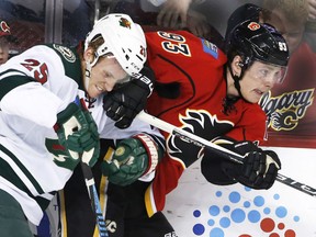 Jonas Brodin, left, of the Minnesota Wild, has a board meeting with Sam Bennett of the Calgary Flames during NHL action Friday in Calgary. The Flames were 3-2 winners in a shootout.