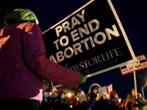 Mary Hoffmeyer, of Taos, Mo., holds a sign as she and other anti-abortion advocates sing Christmas carols after attending a news conference accusing Planned Parenthood facilities of being unsafe outside the Planned Parenthood Columbia Health Center on Monday, Dec. 12, 2016 in Columbia, Mo.