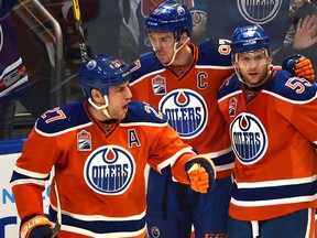Milan Lucic, left, celebrates his goal with Oilers teammates Connor McDavid and Mark Letestu against the Tampa Bay Lightning during second period action at Rogers Place in Edmonton on Saturday night.