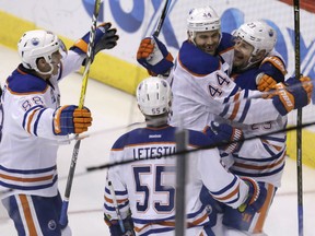 Matt Hendricks (23) celebrates with Oilers teammates Zack Kassian (44), Brandon Davidson (88), and Mark Letestu (55) after scoring a goal against the Arizona Coyotes in the second period of their game, Wednesday night in Glendale, Ariz.