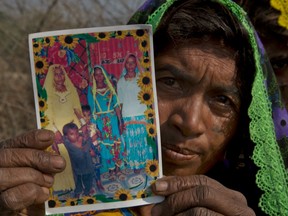 In this photo taken on Thursday, Dec. 1, 2016, Ameri Kashi Kolhi shows picture of her daughter Jeevti, right, in Payro Lundh, Pakistan.