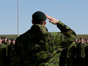 Brig.-Gen. Christian Juneau salutes the troops during National Day of Honour ceremonies at CFB Edmonton in Edmonton, Alta., on Friday, May 9, 2014.