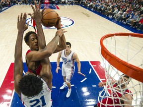 Toronto Raptors guard DeMar DeRozan goes up for the shot with 76ers centre Joel Embiid defending during the second half of their game, Wednesday night in Philadelphia. The Raptors won 123-114.