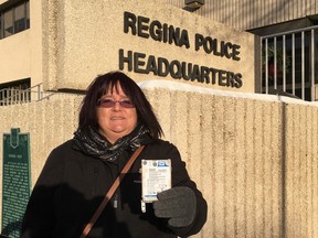 Tracy Britton stands in front of Regina Police Headquarters on Tuesday, Dec.13, 2016 with what remains of her destroyed laptop.