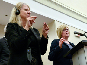 A sign language interpreter signs as Minister of Sport and Persons with Disabilities Carla Qualtrough speaks during an announcement on the UN Convention on the Rights of Persons with Disabilities, on Thursday, Dec. 1, 2016 in Ottawa.