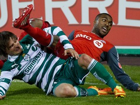 In this March 28, 2012 file photo, Toronto FC defender Ashtone Morgan (right) lies tangled up on the pitch with an opponent from Mexico's Santos Laguna during a CONCACAF Champions League semi-final in Toronto.