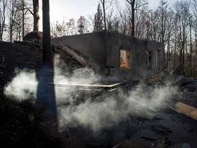 Smoke billows from the remains of a home on the outskirts of Gatlinburg, Tenn.   A devastating wildfire destroyed much of the town this week.