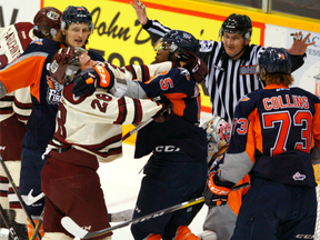 Flint Firebirds defenceman Jalen Smereck (second from right) jousts with Peterborough Petes forward Logan DeNoble on Oct. 27.