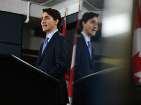 Prime Minister Justin Trudeau is reflected in a TV monitor as he holds a press conference at the National Press Theatre in Ottawa on Monday, Dec. 12, 2016.