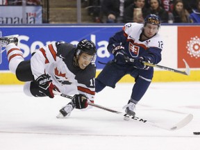 Canada's Mathieu Joseph is tripped by Slovakia’s Marian Studenic as Canada plays Slovakia in World Junior hockey in Toronto on Tuesday. Canada won 5-0.