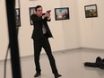 An unnamed gunman gestures after shooting the Russian Ambassador to Turkey, Andrei Karlov, at a photo gallery in Ankara, Turkey, Monday, Dec. 19, 2016