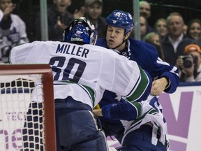 Vancouver Canucks goalie Ryan Miller (left) goes after Toronto Maple Leafs forward Matt Martin during their Nov. 5 game in Toronto.