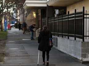 A woman walks by the Victoria Central Baptist Church along Pandora Ave. which recently installed a wall and fence in an effort to keep away drug users and homeless people.