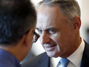 MLB commissioner Rob Manfred (right) listens during a conversation at baseball's winter meetings in Oxon Hill, Md. on Dec. 5.