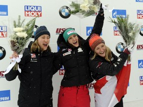First-place finisher Janine Flock of Austria, centre, second-place Lizzy Yarnold, of Britain and third place finisher Mirela Rahneva of Canada, right, celebrate after the World Cup women's skeleton event on Saturday in Lake Placid, N.Y.