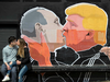 n this Saturday, May 14, 2016 file photo a couple kisses in front of graffiti depicting Russian President Vladimir Putin, left, and Republican presidential candidate Donald Trump, on the walls of a bar in the old town in Vilnius, Lithuania.