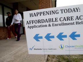 An Affordable Care Act application and enrollment sign stands outside a Westside Family Healthcare center in Bear, Delaware, U.S., on Thursday, March 27, 2014