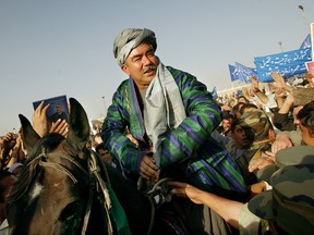 Abdul Rashid Dostum sits on a horse during his final campaign rally October 6,2004 at Kabul stadium in Kabul, Afghanistan.